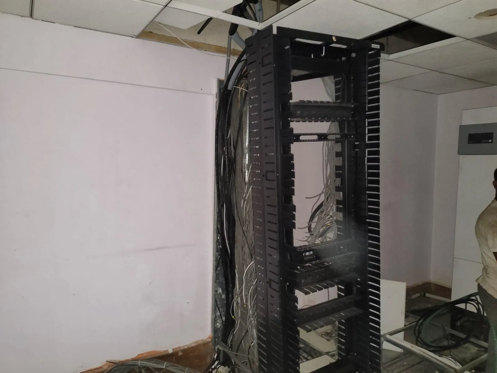 Exposed network cabling lines, server racks, and power buses during an IT office decommissioning service in Electronic City