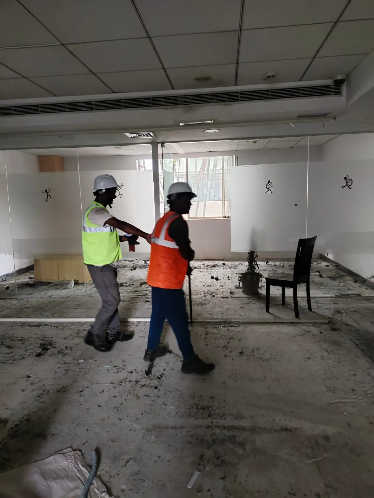 Professional technician wearing safety equipment removing commercial floor layouts during an office dismantling project in Electronic City, Bengaluru